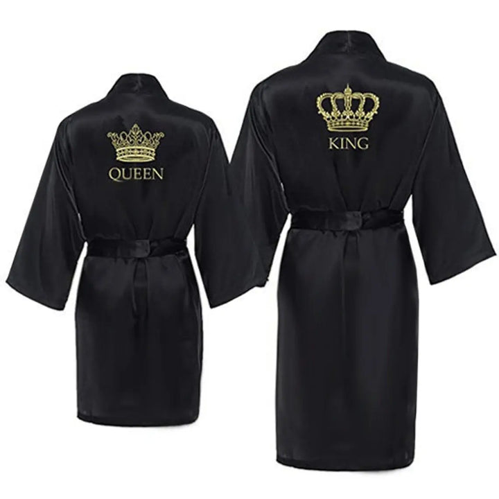 Chic satin black couple’s bathrobes from CouplesChoices.com, featuring regal gold “King” and “Queen” embroidery with intricate crown designs—elegant, lightweight loungewear crafted for style, comfort, and royal romance.