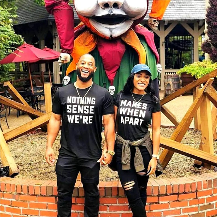 Couple wearing matching black shirts that read 'Nothing Makes Sense We’re' and 'Makes When Apart'—a playful and heartfelt message when worn together. Perfect for couples who want to show love and humor. From CouplesChoices.com.