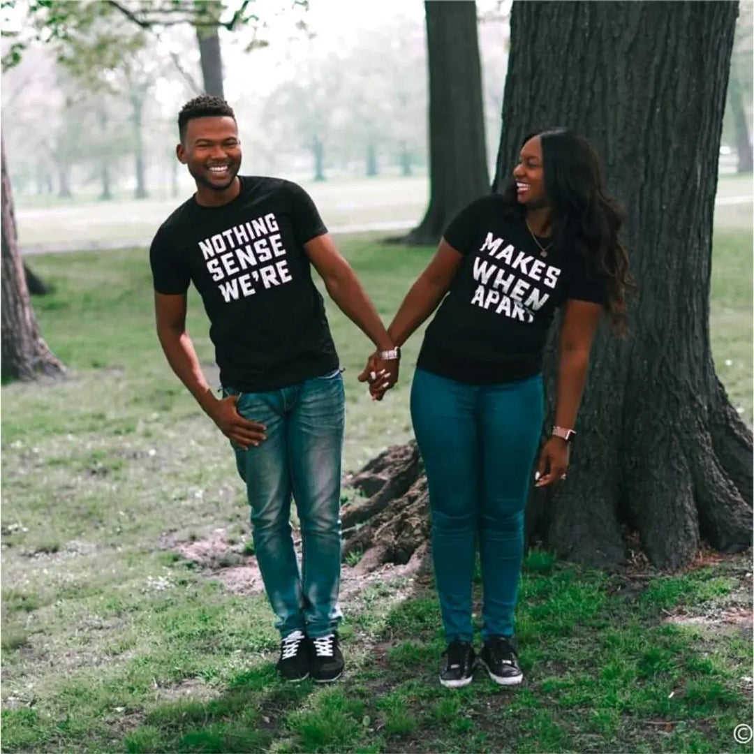 Couple wearing matching black shirts that read 'Nothing Makes Sense We’re' and 'Makes When Apart'—a playful and heartfelt message when worn together. Perfect for couples who want to show love and humor. From CouplesChoices.com.