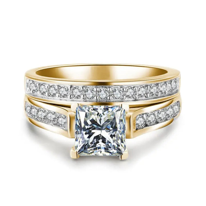 CouplesChoices.com Gold Royalty Rings – A radiant bridal set with a princess-cut diamond and pavé accents, paired with a bold men’s gold band featuring channel-set diamonds. A powerful symbol of regal love and lifelong unity.