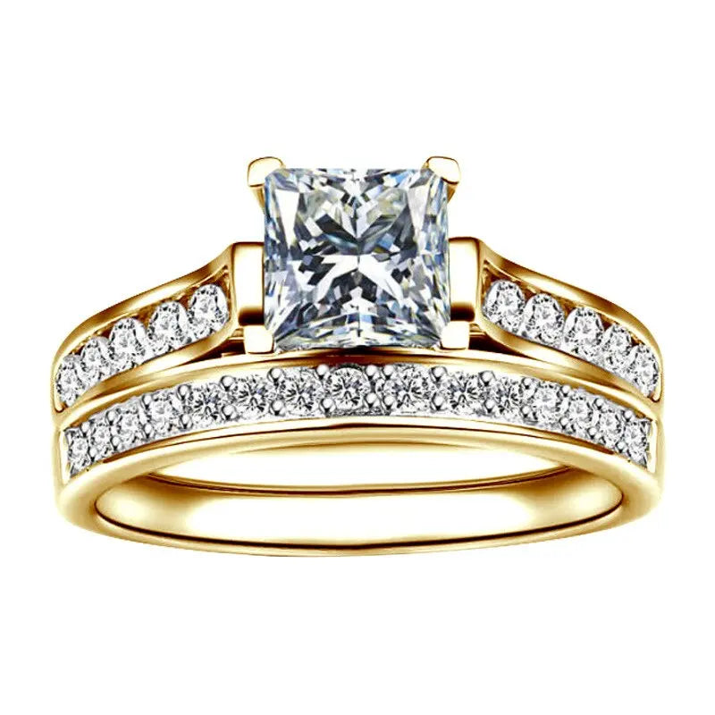 CouplesChoices.com Gold Royalty Rings – A radiant bridal set with a princess-cut diamond and pavé accents, paired with a bold men’s gold band featuring channel-set diamonds. A powerful symbol of regal love and lifelong unity.