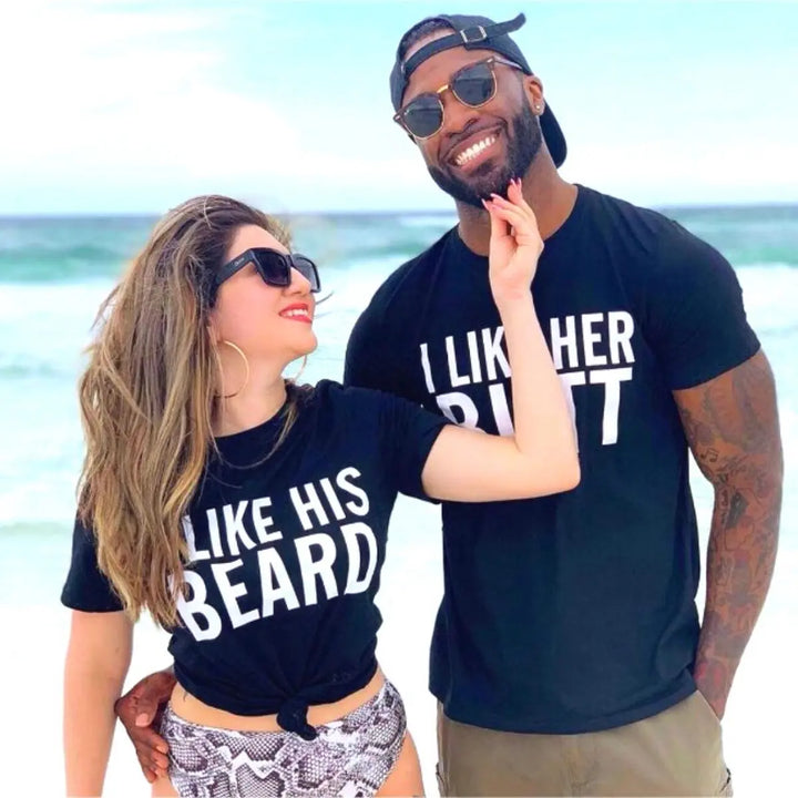 Couples matching black T-shirts from CouplesChoices.com—hers reads “I Like His Beard” and his says “I Like Her Butt.” A fun, cheeky way to show off attraction, personality, and a playful connection in modern relationships.