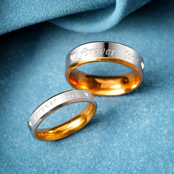 Elegant Forever Love Rings by CouplesChoices.com in radiant gold and silver tones, engraved with hearts and timeless words—crafted to symbolize eternal commitment and cherished connection.
