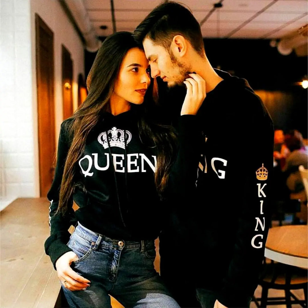 Matching black couple hoodies from CouplesChoices.com with bold white “KING” and “QUEEN” lettering and crown graphics on the chest, sleeves, and hood. A timeless, coordinated set designed for couples who lead with love and royalty.