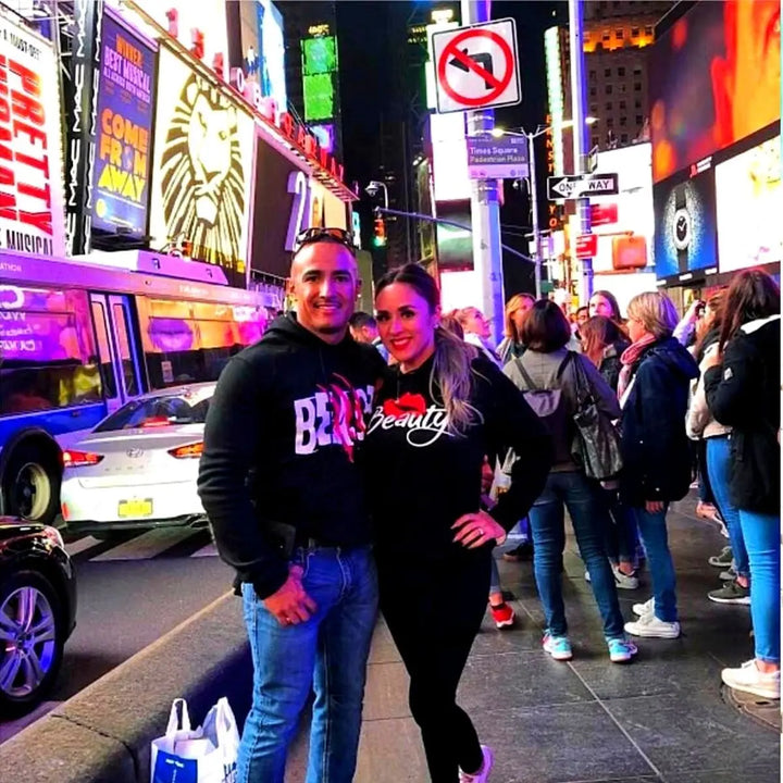 Matching black couple hoodies from CouplesChoices.com with bold white text—his reads “BEAST” with red claw marks, and hers says “Beauty” with a red lipstick kiss graphic. A fun, edgy set for couples who embrace fierce love and playful contrasts.