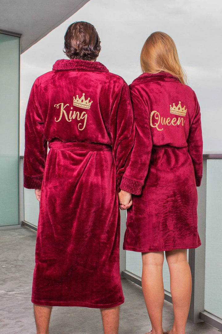 Plush deep red “King” and “Queen” couple’s bathrobes from CouplesChoices.com, featuring gold embroidered crowns and lettering—romantic, regal loungewear designed for cozy elegance and timeless couple style.
