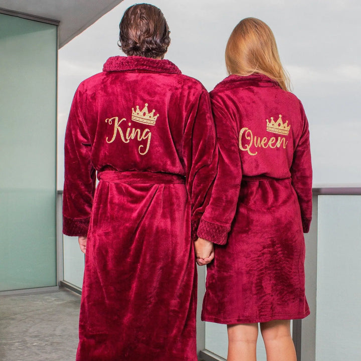 Plush deep red “King” and “Queen” couple’s bathrobes from CouplesChoices.com, featuring gold embroidered crowns and lettering—romantic, regal loungewear designed for cozy elegance and timeless couple style.